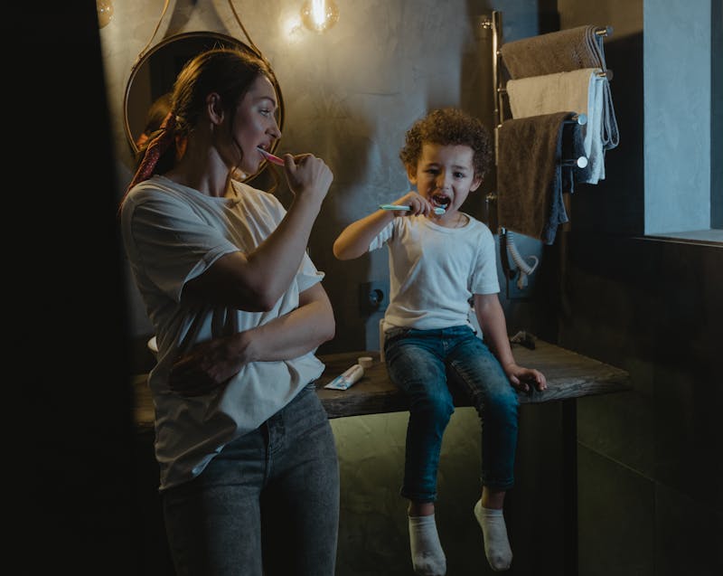 mother and kid brushing their teeth