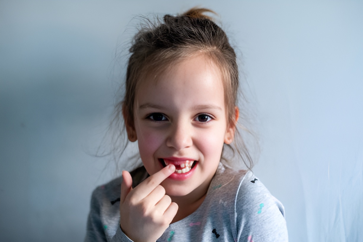 girl with missing teeth, smiling