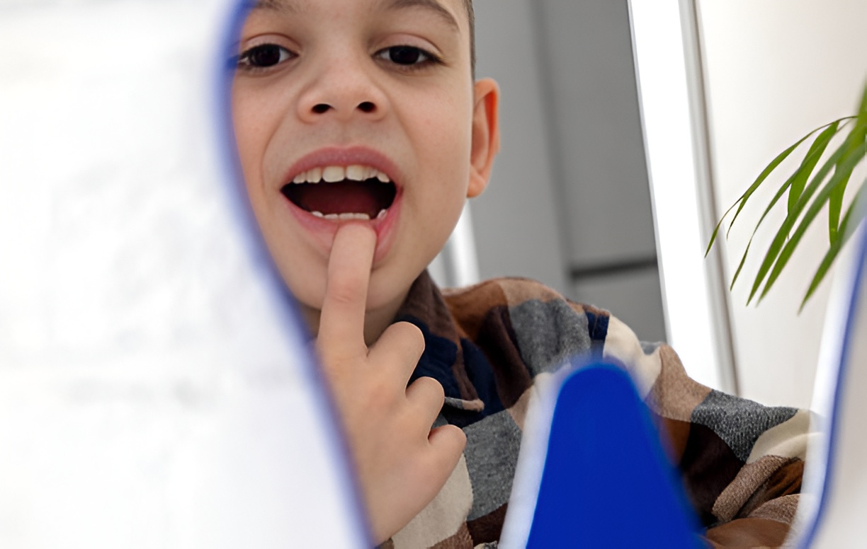 boy with a missing tooth, looking in a mirror